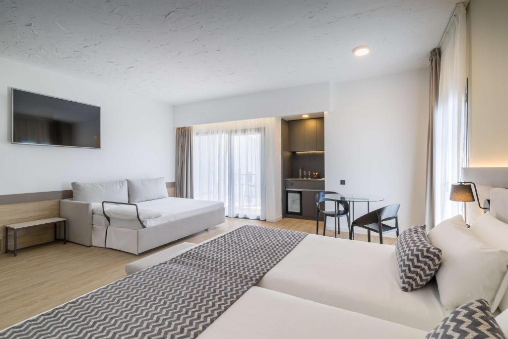 Mūsdienīgs viesnīcas numurs ar divām gultām, dīvānu, virtuves stūri un balkonu. Gaisma un neitrālas krāsas rada mājīgu atmosfēru.