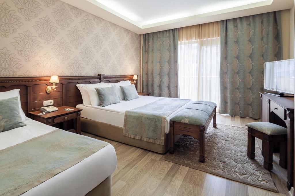 Elegants viesnīcas numurs ar divām gultām, dekorēts ar mīkstām krāsām un modernu mēbeļu dizainu. Logi ar viegliem aizkariem ļauj ienākt dabiskajai gaismai.