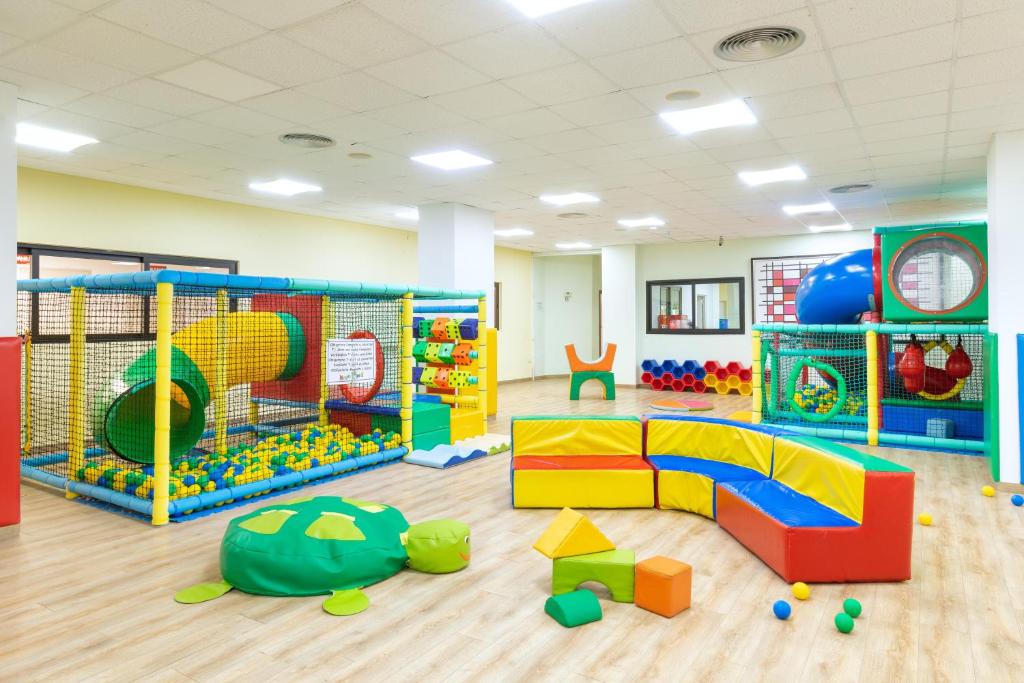 Krāsaina bērnu spēļu zona ar spēļu struktūrām, slīdēšanu un mīkstiem elementiem, kas veidoti no dažādām krāsām un formām. Telpa ir plaša un gaiša, nodrošinot drošu vidi bērnu rotaļām.
