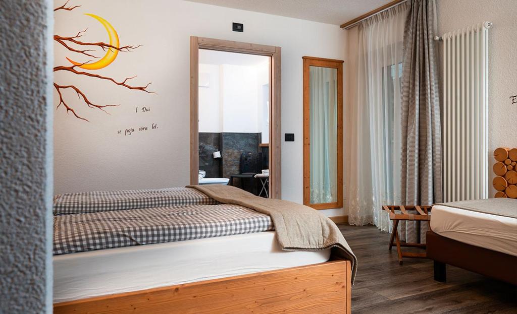 Mūsdienīgs viesnīcas numurs ar divām gultām, dekorēts ar koka zaru un saules attēlu uz sienas. Numurā ir liels spogulis, aizkari un mūsdienīga apgaismojuma sistēma.