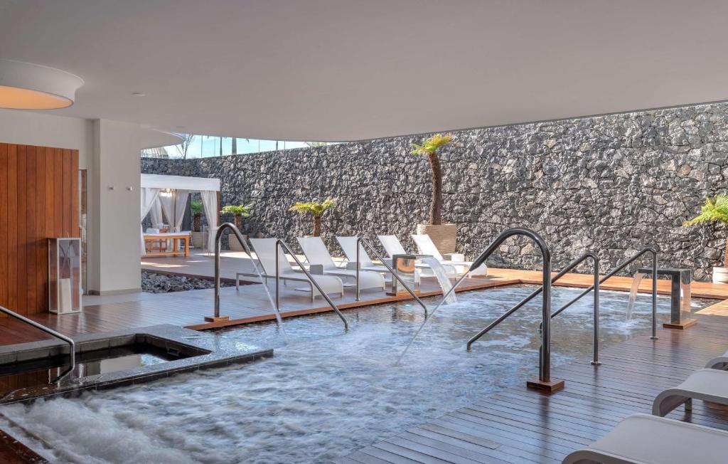 Mūsdienīgs spa ar relaksējošu ūdens elementu un komfortablām sauļošanās krēslām, kas atrodas elegantā interjerā. Ideāla vieta atpūtai un relaksācijai.
