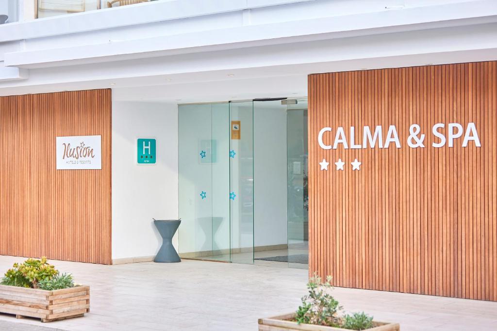Kalma un SPA viesnīcas ieeja ar mūsdienīgu dizainu un koka apdari. Redzams viesnīcas nosaukums un simbols, kas norāda uz viesnīcas statusu.