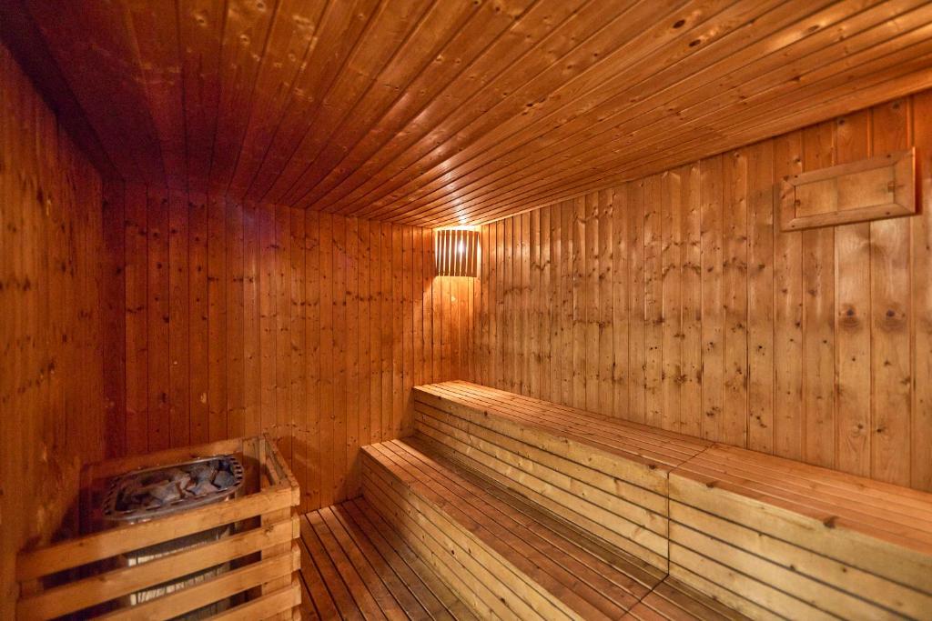 Koka saunas iekšiene ar siltām, dabīgām krāsām un koka sēdekļiem, radot relaksējošu atmosfēru. Ideāla vieta atpūtai un atjaunošanai.