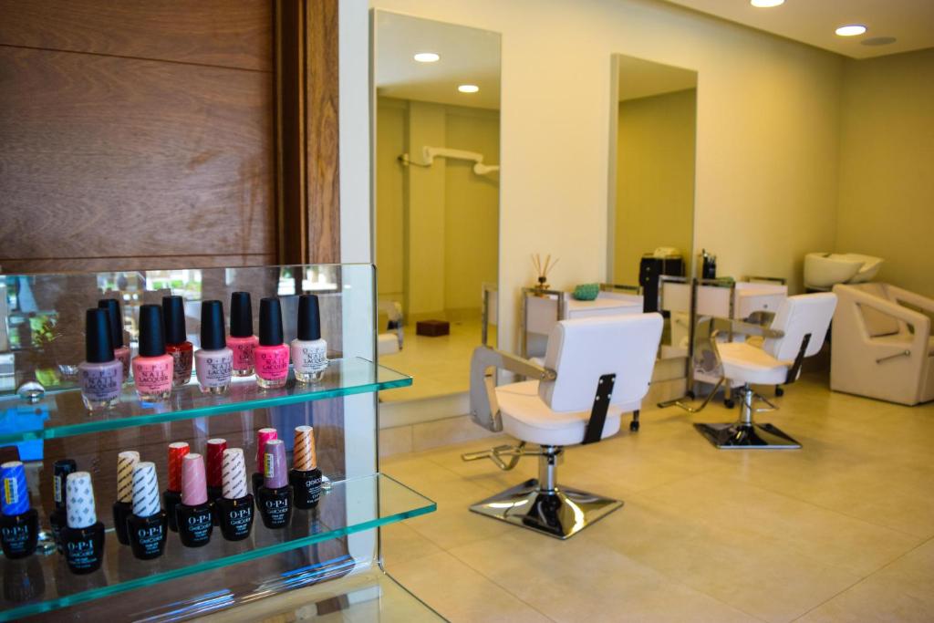 Skaistumkopšanas salons ar manikīra lakām un stilīgām frizieru krēslām, nodrošinot relaksējošu vidi. Interjers ir gaišs un moderns, ar plašām spoguļtelpām.