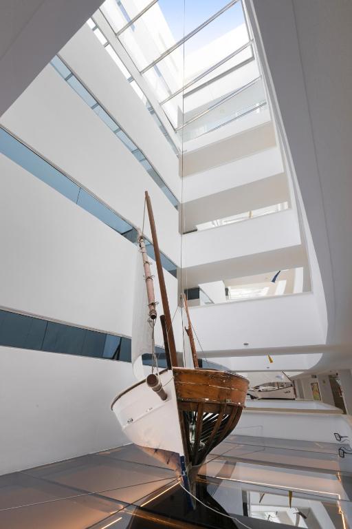 Mūsdienīgs interjers ar pakārtotu laivu, kas izceļas ar mūsdienīgu arhitektūru un gaismas plūsmu.