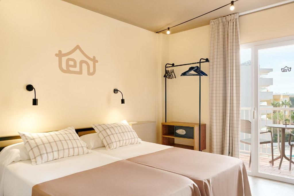 Mūsdienīga viesnīcas numura iekārtojums ar divām gultām, stilīgu apgaismojumu un balkonu, kas paver skatu uz ārējo vidi.