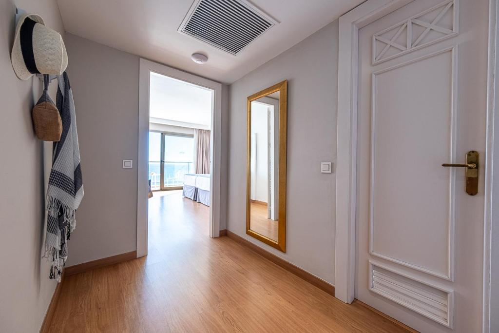 Mūsdienīga un gaiša ieejas telpa ar koka grīdu, dekorēta ar spoguli un aksesuāriem, piemēram, cepuri un somu, kas rada viesmīlīgu atmosfēru.