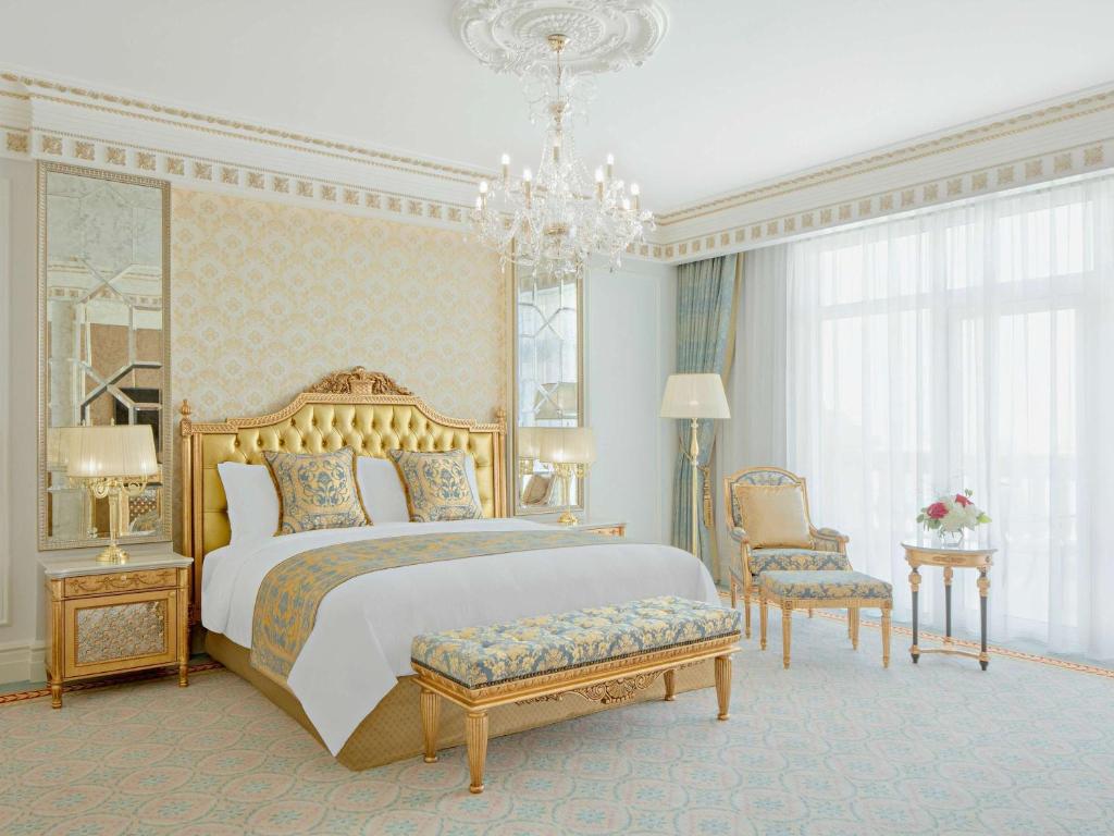Greznas guļamistabas interjers ar zelta akcentiem, elegantu gultu un stilīgu mēbeļu komplektu. Telpā ir lieli logi, kas nodrošina dabisko apgaismojumu.