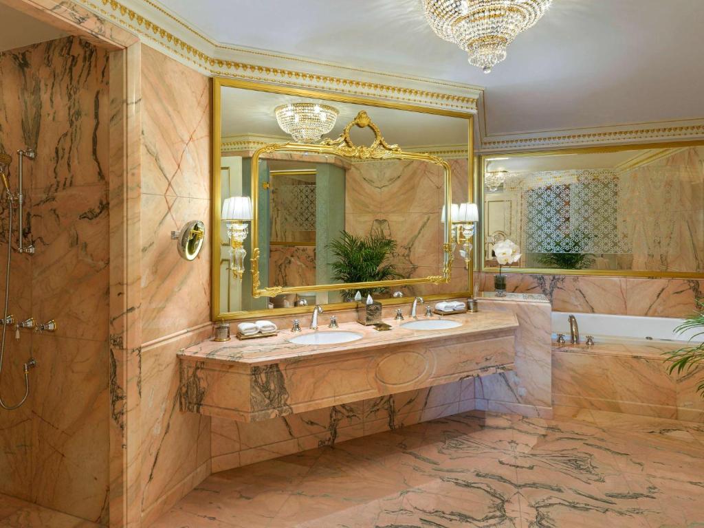 Luksusa vannas istaba ar rožainu marmoru, elegantu spoguli un izsmalcinātiem gaismas ķermeņiem, radot greznu atmosfēru. Vannas istabā ir arī brīnišķīgs augs un vannas, kas papildina kopējo estētiku.