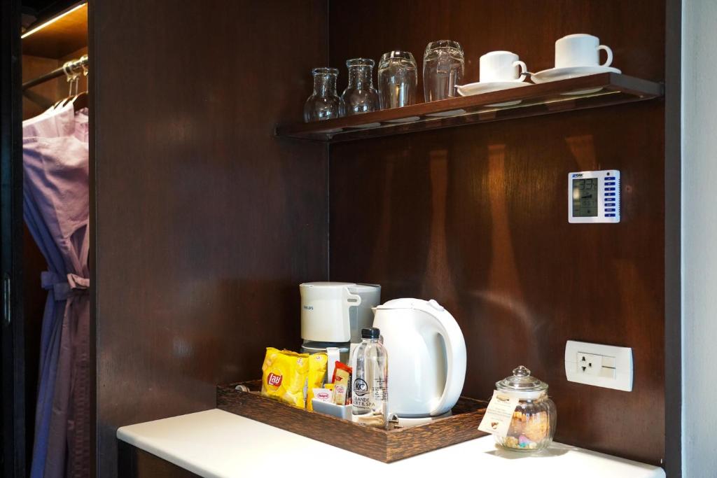Brokastis viesnīcā: kafejnīcas piederumi, elektriskā tējkanna un uzkodu izvēle uz galda.