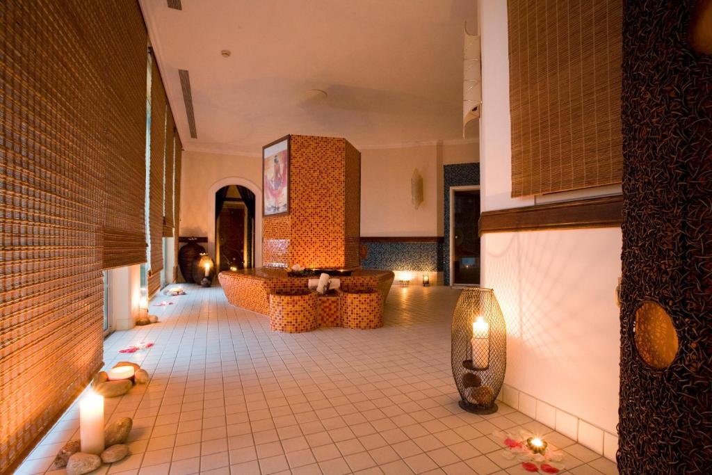 Spa telpa ar relaksējošu atmosfēru, apgaismotu ar svecēm un rotājumus no dabīgām akmeņiem. Sienas dekorētas ar dabīgiem materiāliem, radot mierīgu un harmonisku vidi.