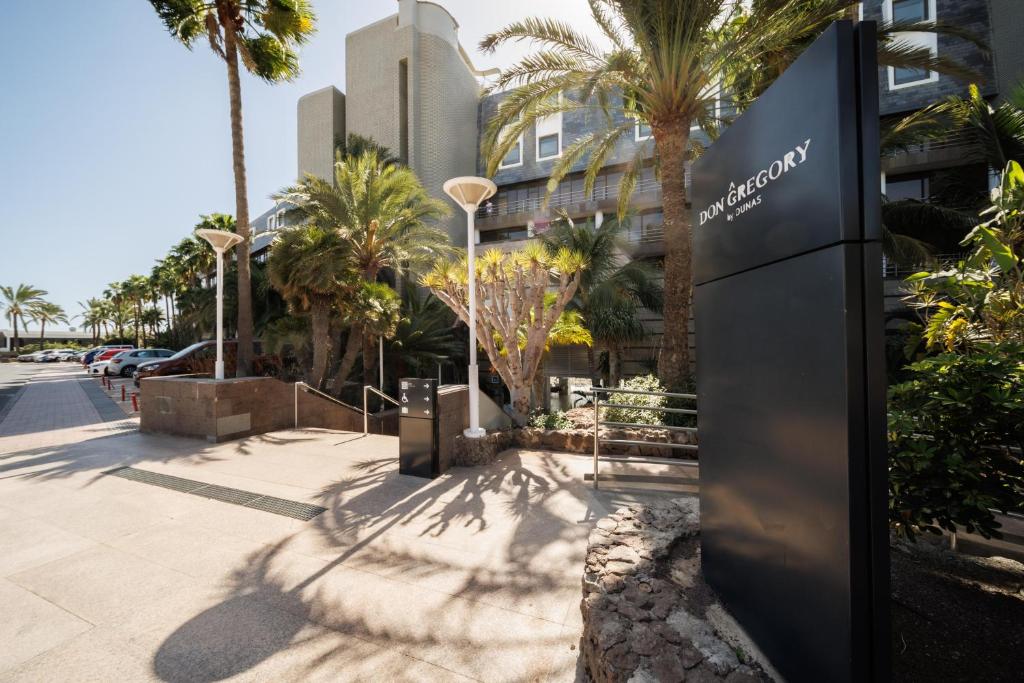 Mūsdienīgs viesnīcas "Don Gregory" ieejas skats ar palmām un saulainu laiku, kas rada patīkamu atmosfēru. Viesnīca atrodas pie jūras, piedāvājot vieglu piekļuvi pludmalei.