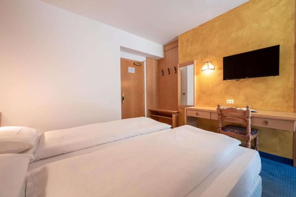 Mūsdienīgs viesnīcas numuriņš ar divām gultām, tv ekrānu un koka mēbelēm. Siltas krāsas sienas un minimālistisks dizains rada mājīgu atmosfēru.