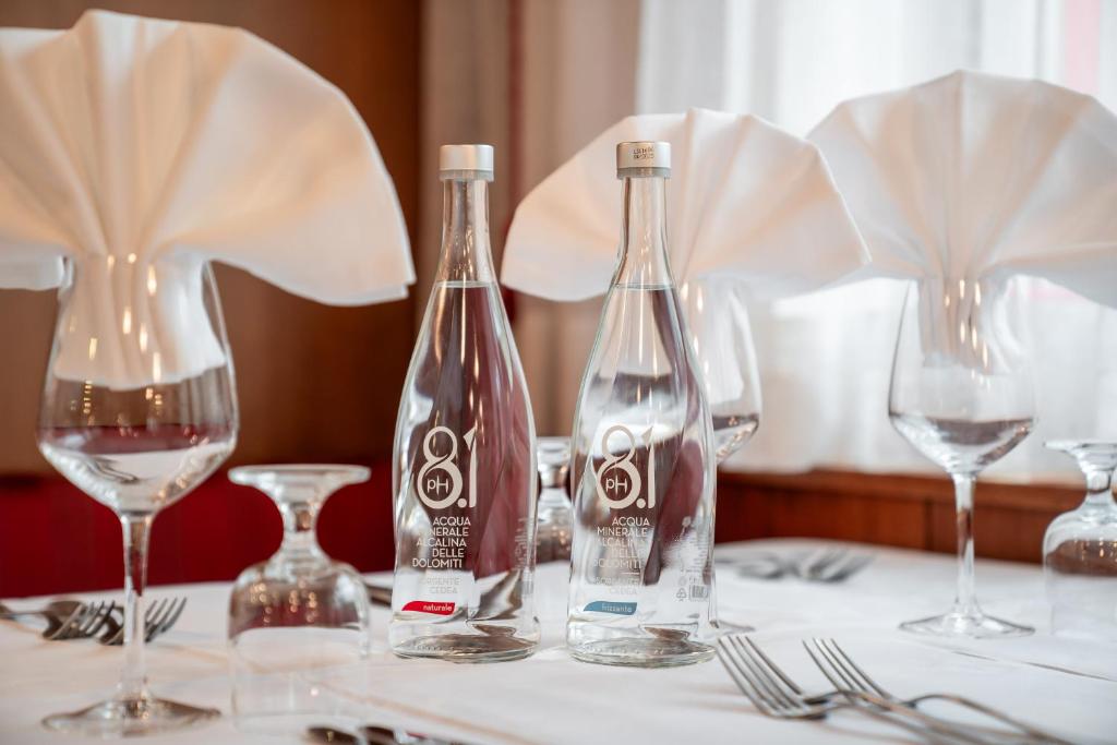 Galda uzstādījums ar divām minerālūdens pudelēm un eleganti salocītiem salvetēm. Ideāli piemērots restorāna atmosfērai.