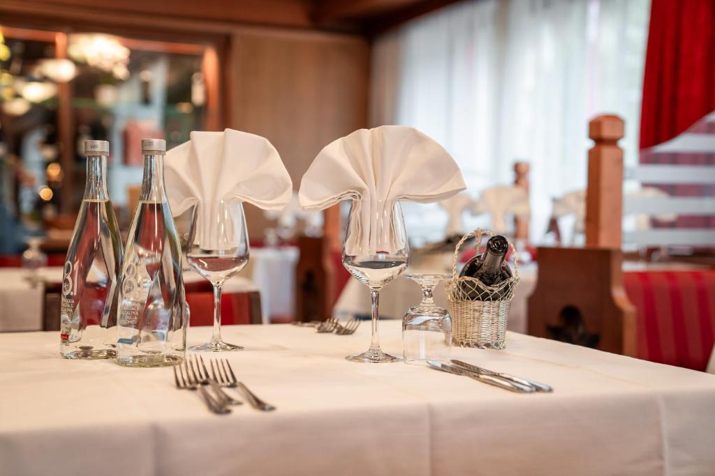 Elegants restorāna galda klājums ar ūdens pudelēm, vīna glāzēm un salvetēm. Ideāla atmosfēra romantiskām maltītēm vai svinībām.