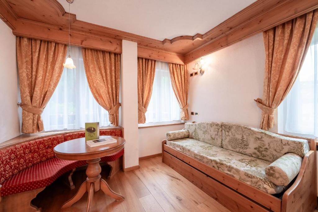 Mūsdienīgs interjers ar koka apdari, mīkstu dīvānu un sarkanu krēslu stūri, rotāts ar zeltainām aizkariem un lieliem logiem, kas nodrošina dabisko apgaismojumu. Ideāla vieta atpūtai un relaksācijai.