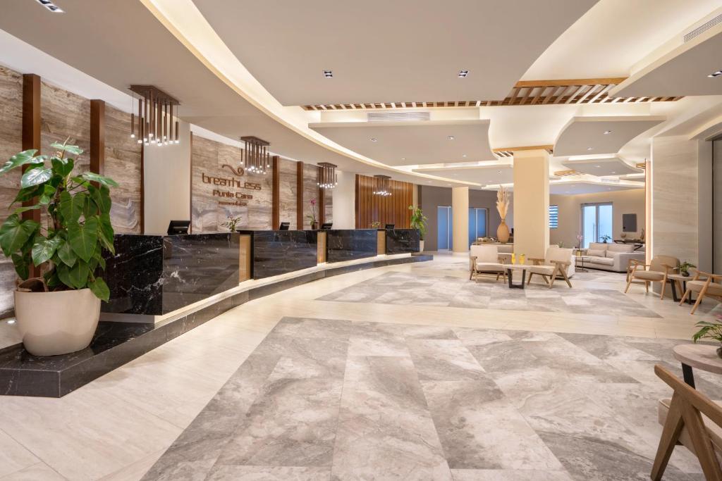 Mūsdienīgs viesnīcas reģistratūras interjers ar elegantām līnijām, komfortablām mēbelēm un zaļām augu kompozīcijām, radot viesmīlīgu atmosfēru. Pārsteidzošs apgaismojums un stilīgas detaļas piešķir telpai unikālu šarmu.