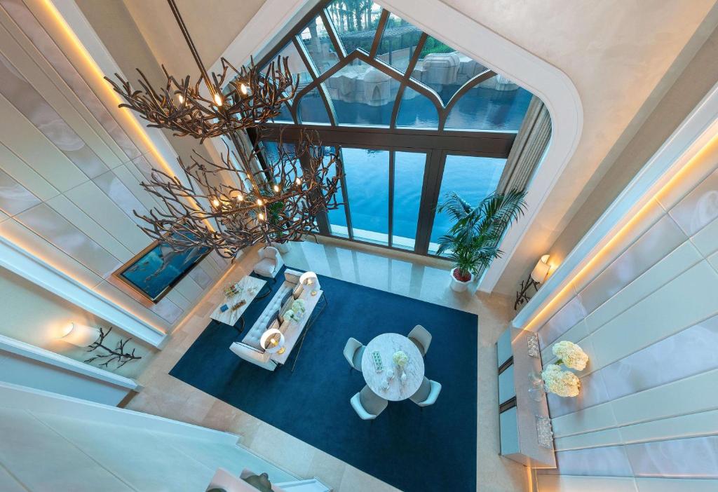 Mūsdienīgs un elegants interjers ar plašu telpu un skatu uz ūdeni. Apgaismojuma elementi un augi papildina atmosfēru.