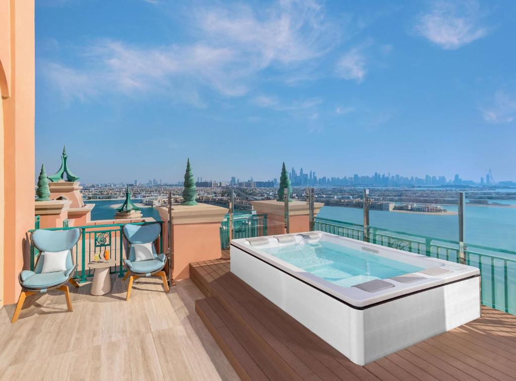 Luksusīga terase ar privātu džakuzi un skatu uz pilsētu, kas sniedz mierīgu atmosfēru atpūtai. Skaisti krēsli un galdiņš papildina telpas estētiku.