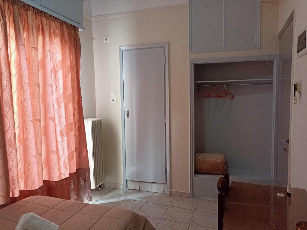 Istaba ar rozā aizkariem, skapja durvīm un siltuma radiatoru. Telpa ir gaiša un vienkārša, radot mājīgu atmosfēru.