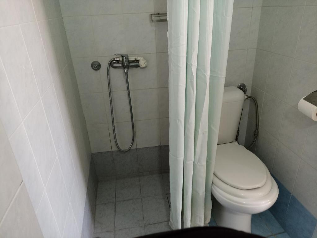 Vannas istaba ar dušu, tualeti un gaišām flīzēm. Telpa ir sakopta un funkcionāla.