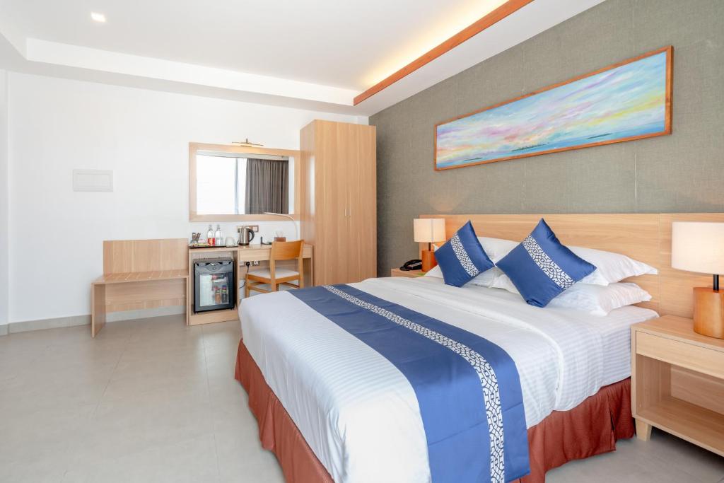 Mūsdienīgs viesnīcas numurs ar divguļamo gultu, koka mēbelēm un skatu uz dekoratīvu gleznas sienu. Numurā ir mini ledusskapis un rakstāmgalds, nodrošinot ērtu atpūtu un darbu.