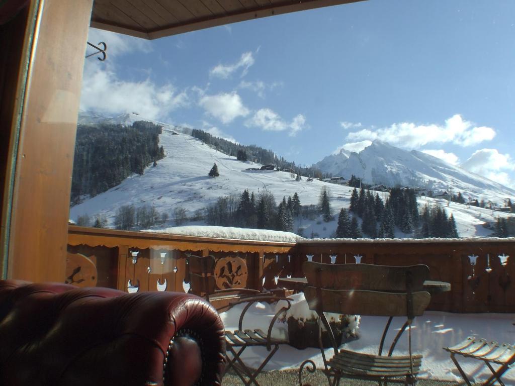 Skaists kalnu skats no balkona ar sniegotu ainavu un saulainu debesi, radot mierīgu un relaksējošu atmosfēru. Ideāla vieta ziemas atpūtai.
