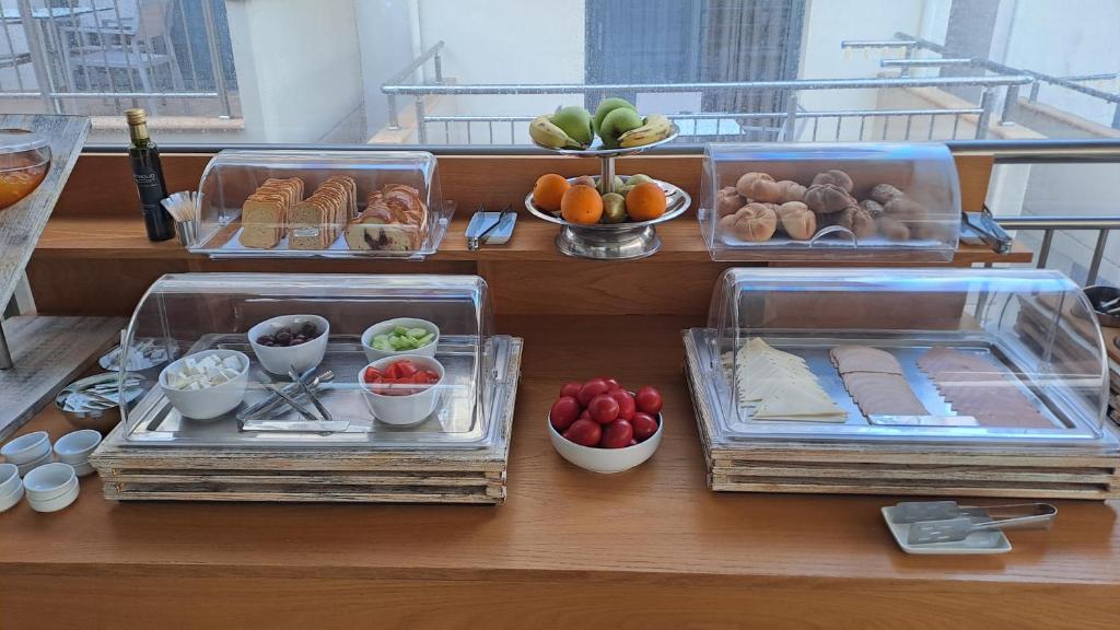 Brokastu bufete ar dažādiem maizes izstrādājumiem, augļiem un dārzeņiem. Izsmalcināti pasniegti produkti, piemēram, siera un gaļas šķēles, kopā ar saldajiem un sulīgajiem augļiem.