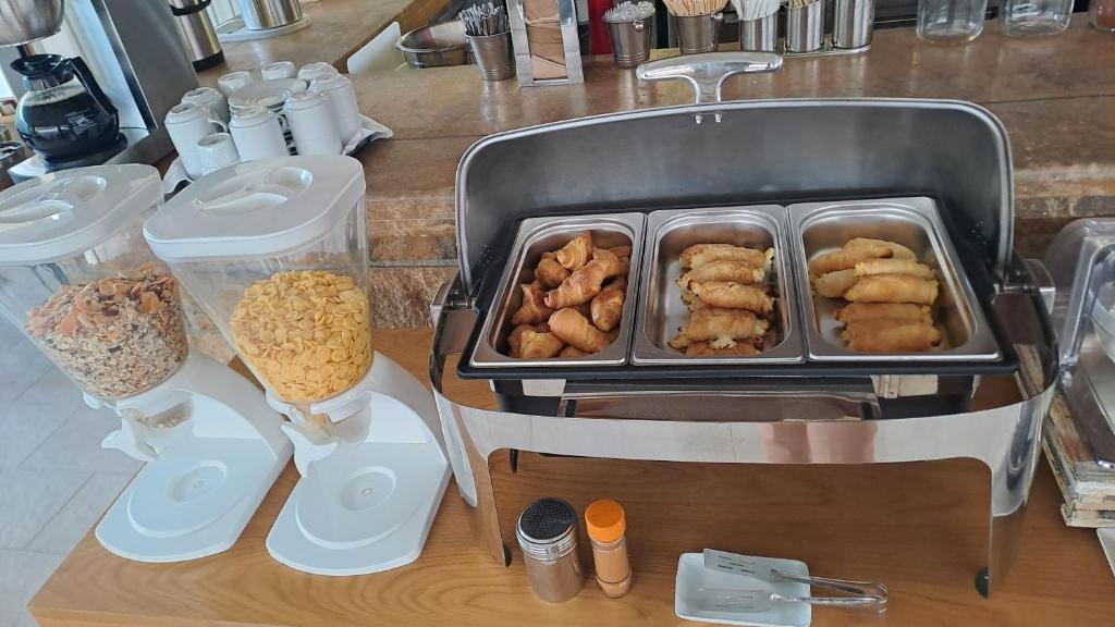 Brokastu bufete ar graudaugiem, riekstiem un dažādām uzkodām, tostarp pildītiem cepumiem.