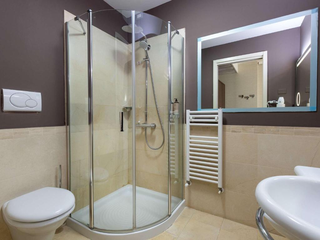 Mūsdienīga vannas istaba ar dušas kabīni, tualeti un spoguli. Telpa ir eleganti iekārtota ar neitrālām krāsām un modernām iekārtām.