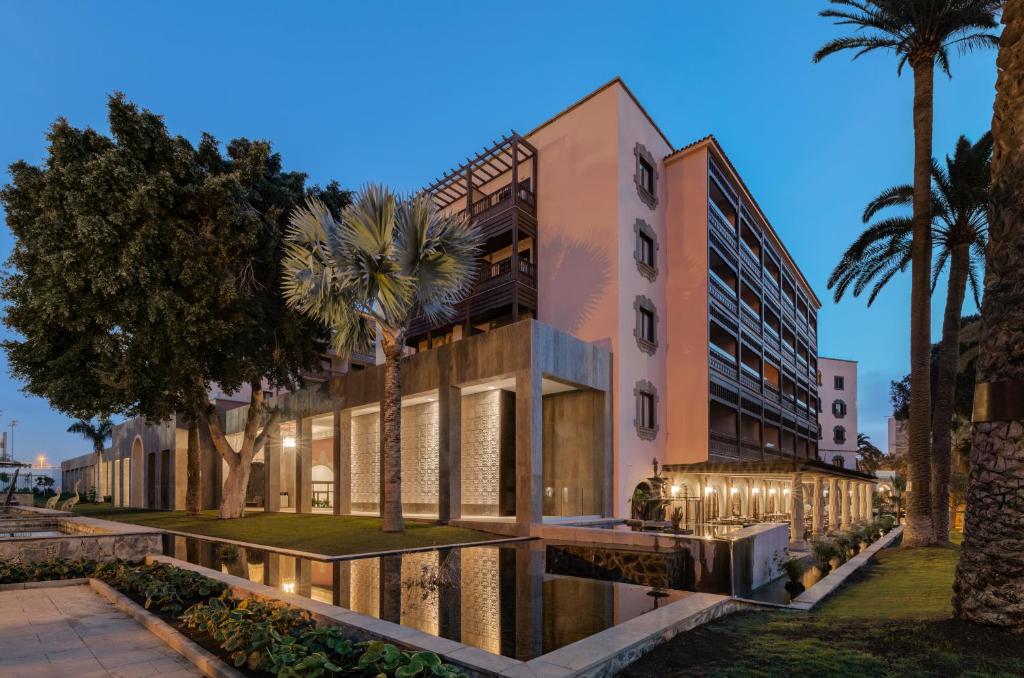 Mūsdienīga viesnīca ar elegantu arhitektūru, kas apņem skaistu dārzu un ūdens elementus, radot relaksējošu atmosfēru. Apgaismojums pievērš uzmanību ēkas detaļām un apkārtējai videi.