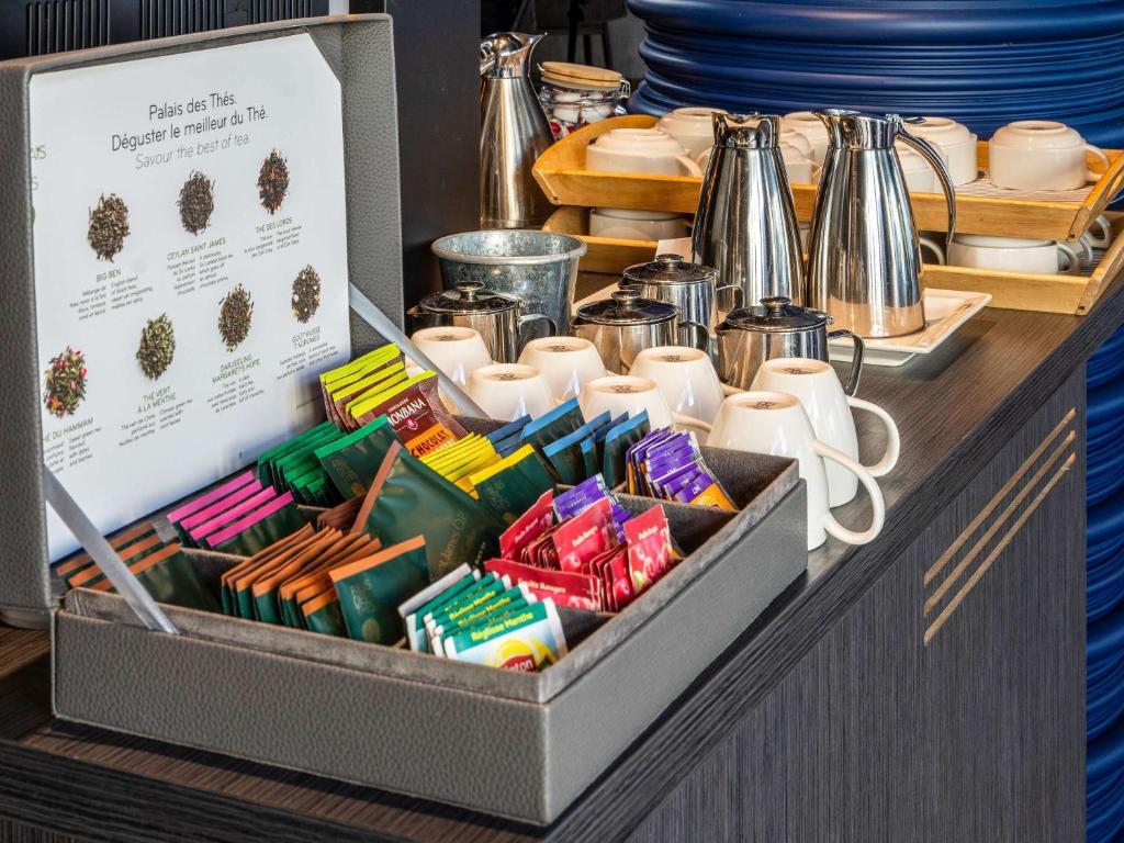 Tēja un kafijas stacija ar dažādiem tēju maisiņiem un traukiem, kas paredzēti dzērieniem. Izvēle no dažādām tējām un eleganta servēšana.