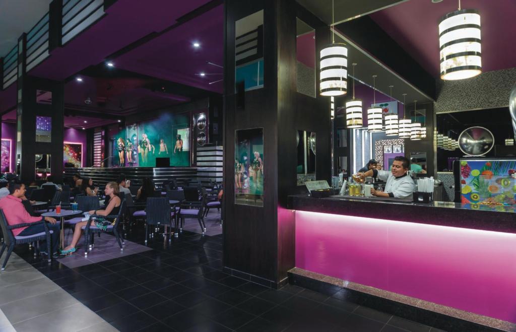 Mūsdienīgs bārs ar stilīgu iekārtojumu, kur viesi bauda dzērienus un skatu uz uzstāšanos. Interjers ir izceļams ar košām krāsām un modernām lampām.