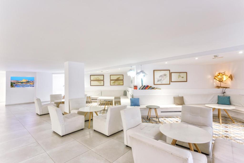 Mūsdienīgs un elegants viesnīcas atpūtas telpas interjers ar baltām mēbelēm, minimālistisku dizainu un mākslas darbiem uz sienām. Interjers ir gaišs un gaisīgs, radot patīkamu atmosfēru.