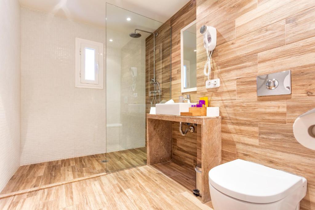 Mūsdienīga vannas istaba ar stikla dušu, koka izskata flīzēm un elegantu izskatu. Iekārtota ar spoguli, roku žāvētāju un sanitāro tehniku.