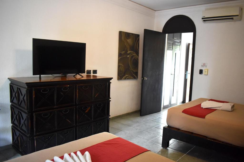 Mūsdienīgs viesnīcas numurs ar divām gultām, melnu televizoru un koka kumodi. Telpai ir gaišas krāsas un liela durvju atvere, kas ved uz ārpusi.