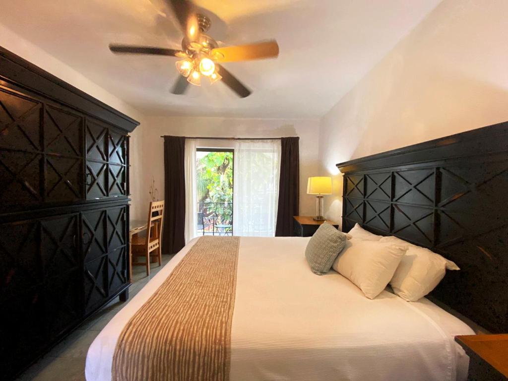 Mūsdienīga guļamistaba ar ērtu gultu, melnu skapju un logu, caur kuru ieplūst dabisks apgaismojums. Gaismas spuldze un krēsls pie galda papildina telpas harmoniju.