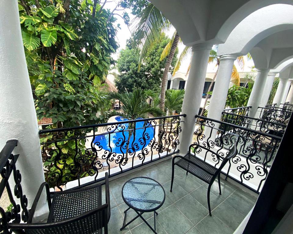 Balkons ar skatu uz baseinu un zaļojošiem kokiem, dekorēts ar melnu metāla žogu un ērtām sēdvietām. Ideāla vieta atpūtai un relaksācijai.