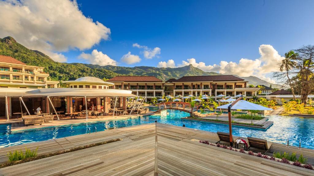 Luksusa kūrorta ainava ar baseinu un kalnu fonu, kas piedāvā relaksējošu atmosfēru un skaistu dabu. Ideāla vieta atpūtai un brīvā laika pavadīšanai.