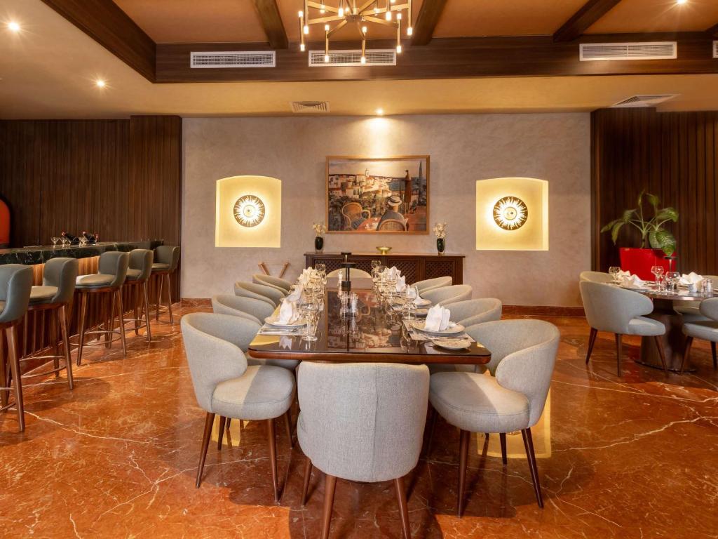 Elegants restorāna interjers ar stilīgām mēbelēm un gleznām uz sienām. Izsmalcināts galda klājums un siltas krāsas rada viesmīlīgu atmosfēru.