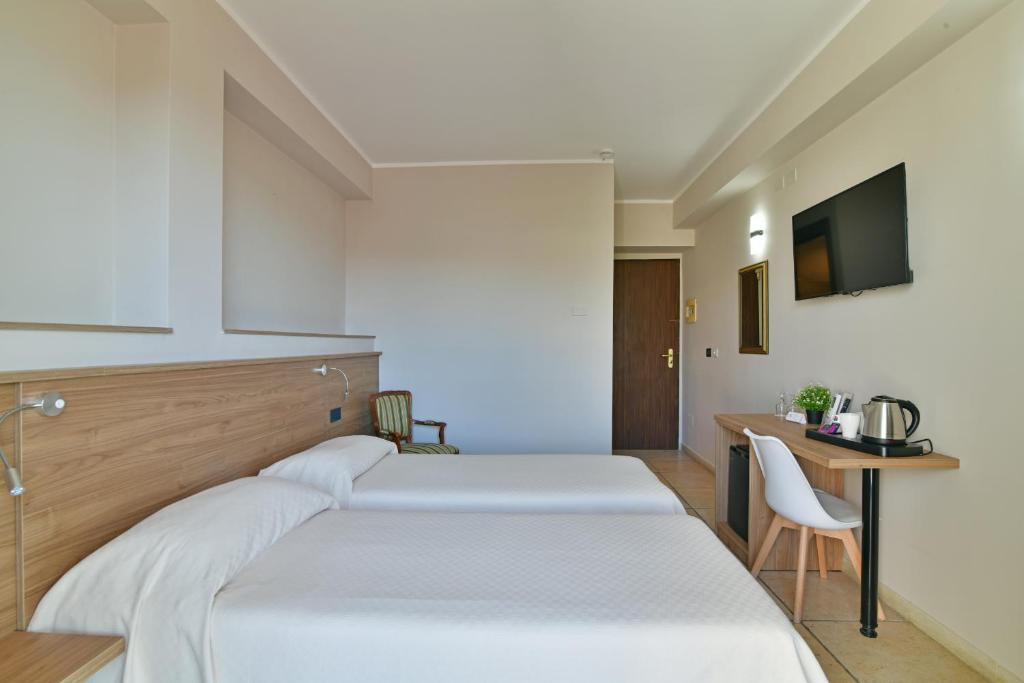 Mūsdienīga viesnīcas istaba ar diviem atsevišķiem gultām, koka apdari un televizoru. Istabā ir galdiņš ar tējkannu un krēsli, kas nodrošina ērtu atpūtu.