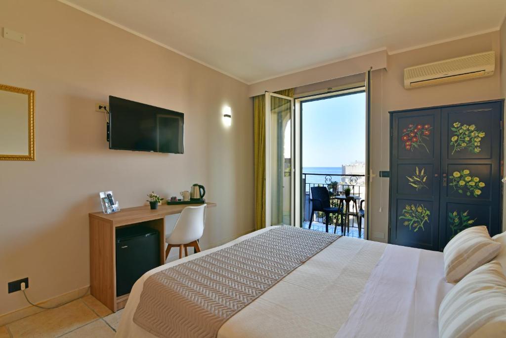 Mūsdienīgs viesnīcas numurs ar balkonu, no kura paveras skats uz jūru. Interjērā ir televizors, galdiņš ar krēslu un krāšņs dekoratīvs skapītis.