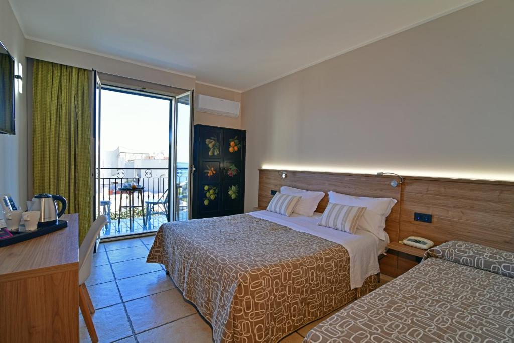 Mūsdienīgs viesnīcas numurs ar divām gultām, koka mēbelēm un balkonu, no kura paveras skats uz ārpusi. Numurā ir arī tējkanna un galda piederumi.