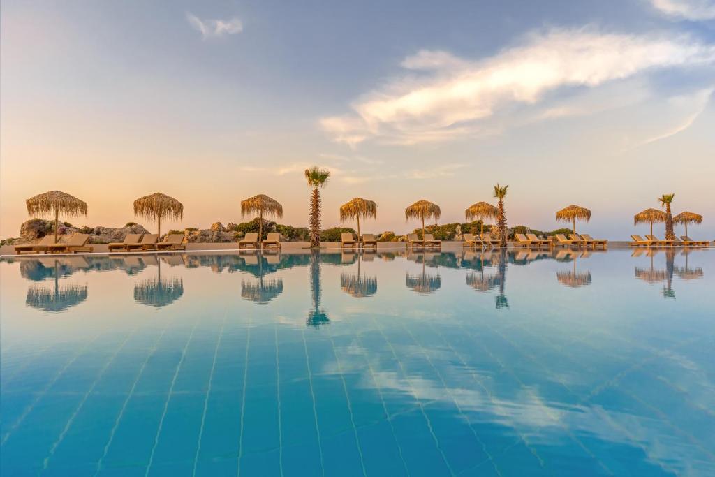 Kresten Royal Euphoria Resort baseina zona piekrastē ar saulessargiem un palmām.