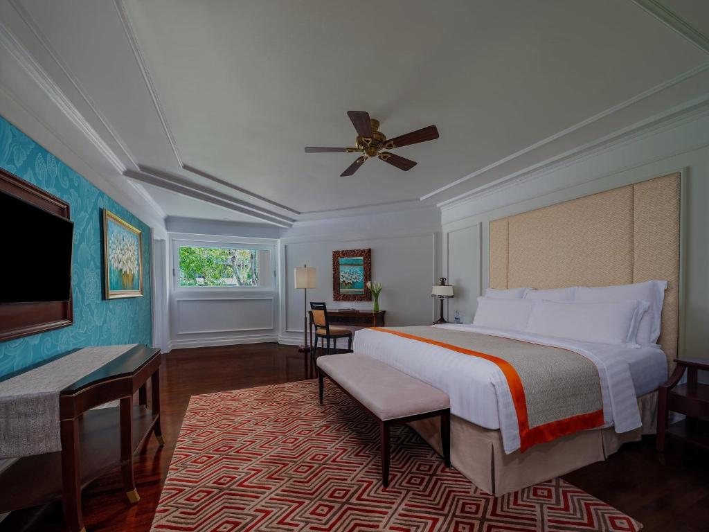 Mūsdienīga guļamistaba ar plašu gultu, elegantu dekora elementu un dabiskiem apgaismojuma risinājumiem. Telpā ir skaisti zila siena un stilīga paklāja dizains, radot relaksējošu atmosfēru.