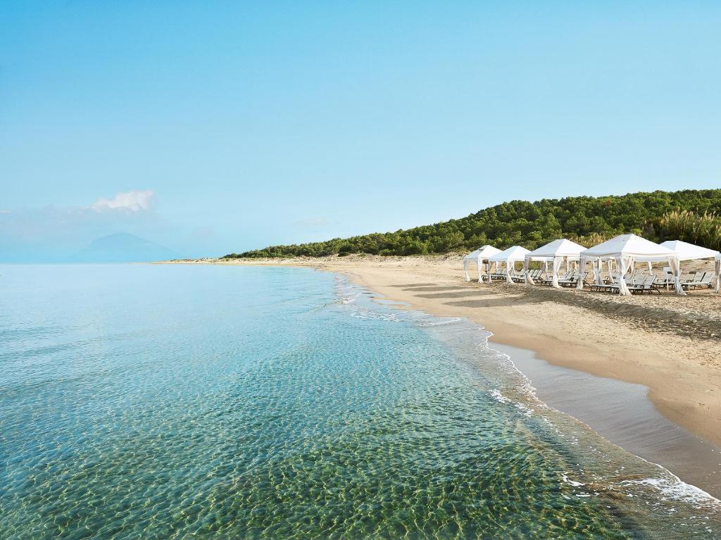 Skaista pludmale ar skaidru ūdeni un baltām pludmales teltīm, kas izvietotas krastā. Ideāla vieta relaksācijai un atpūtai pie jūras.