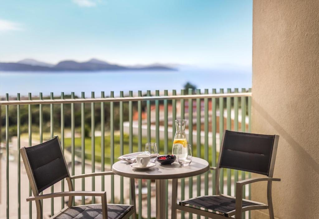 Balkons ar skatu uz jūru, uz kura novietots galds ar kafijas tasi, ūdens krūzi un ogām. Ideāla vieta relaksācijai un nesteidzīgām brokastīm.