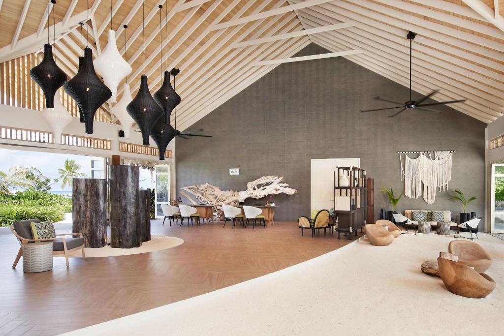 Mūsdienīgs interjers ar augstiem griestiem, elegantiem gaismas ķermeņiem un dabīgiem materiāliem, radot relaksējošu atmosfēru. Telpa ir gaiša un plaša, ar modernām mēbelēm un dekorācijām.