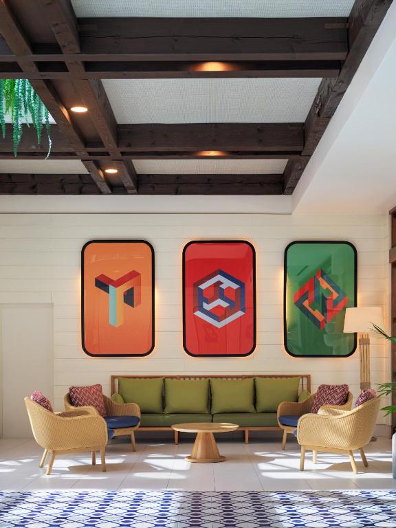 Mūsdienīgs viesnīcas interjers ar krāsainām ilustrācijām uz sienas, ērtiem dīvāniem un koka griestiem. Ideāla vide relaksācijai un sociālām aktivitātēm.