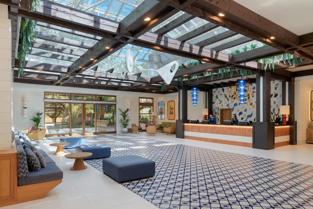 Mūsdienīgs viesnīcas vestibilis ar lielu stikla jumtu, kas piepildīts ar dabīgu gaismu. Interjers ir stilīgs, ar komfortablām mēbelēm un krāsainām dekorācijām.